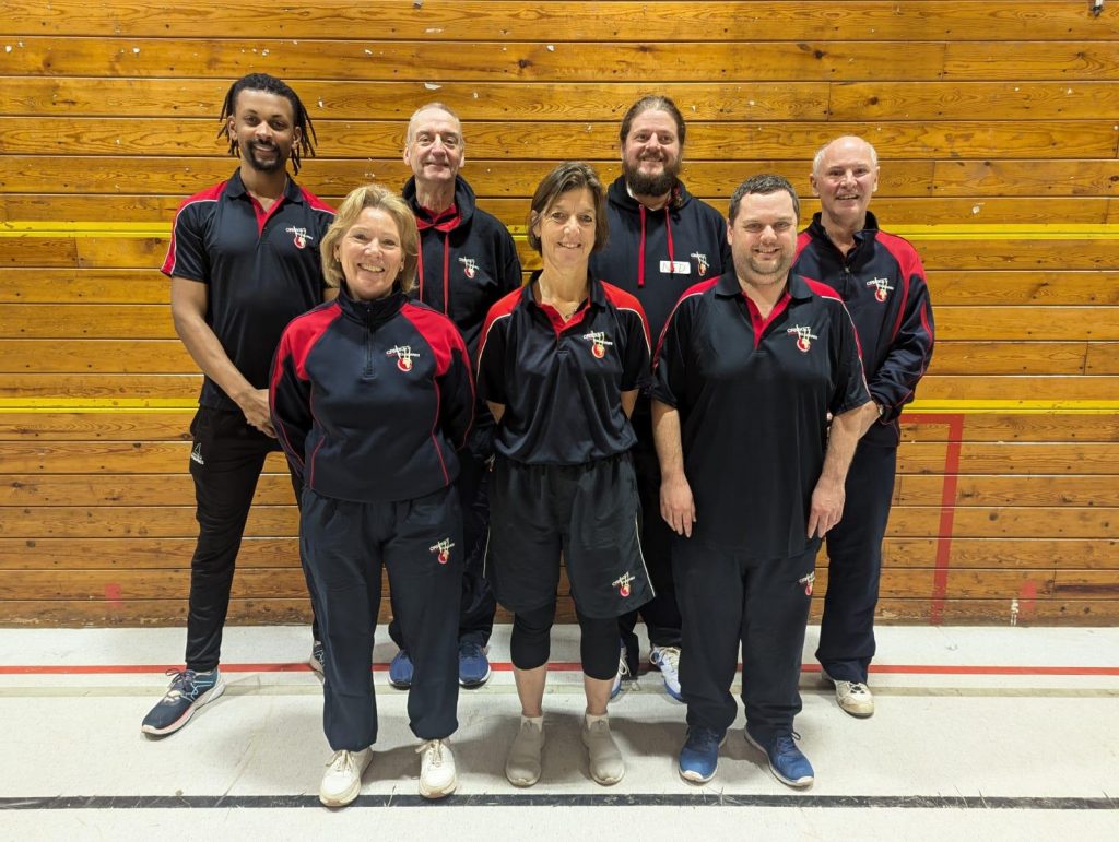 A photo showing the seven members of team Rwanda. the team are stood in a sports hall 